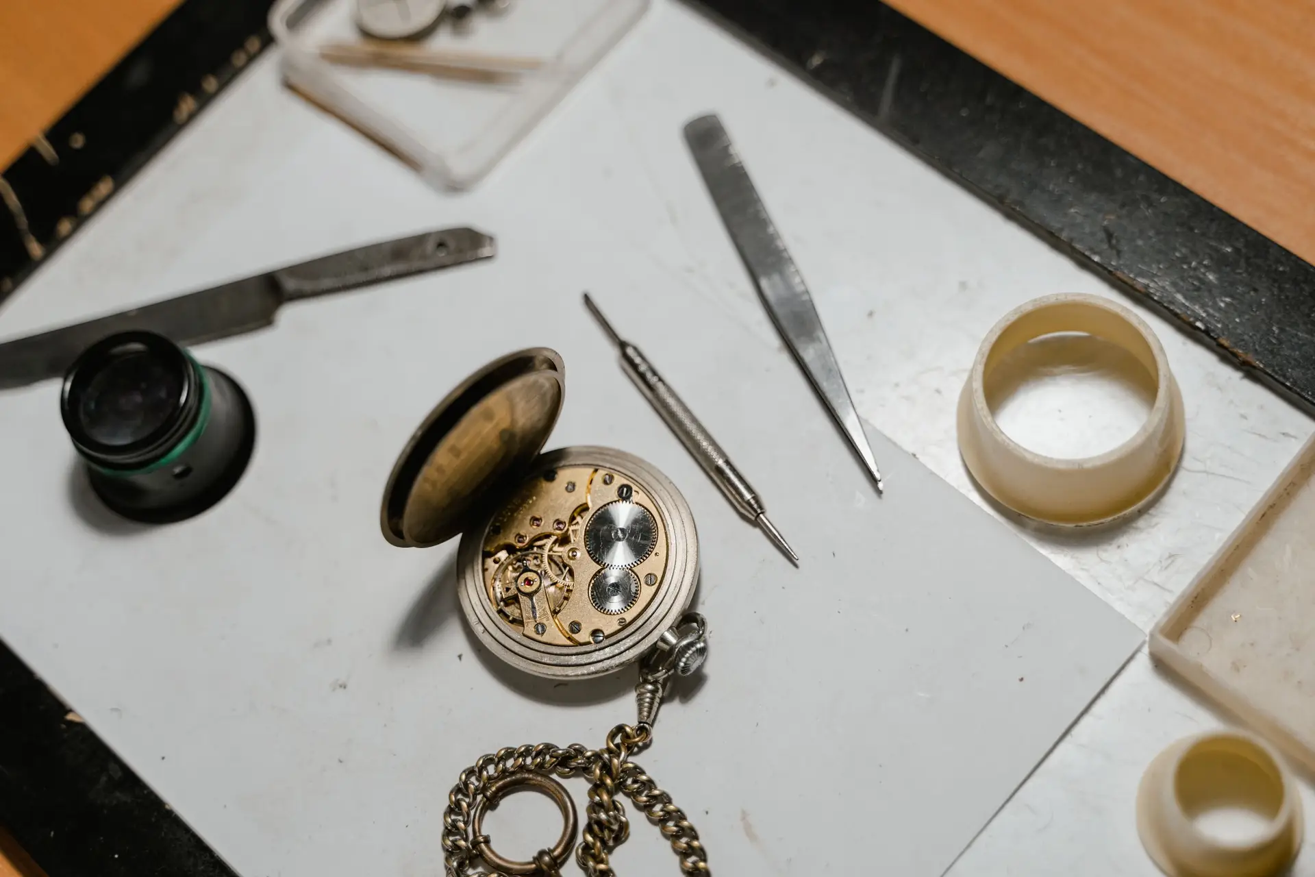 Watch movement parts and precision tools laid out for service