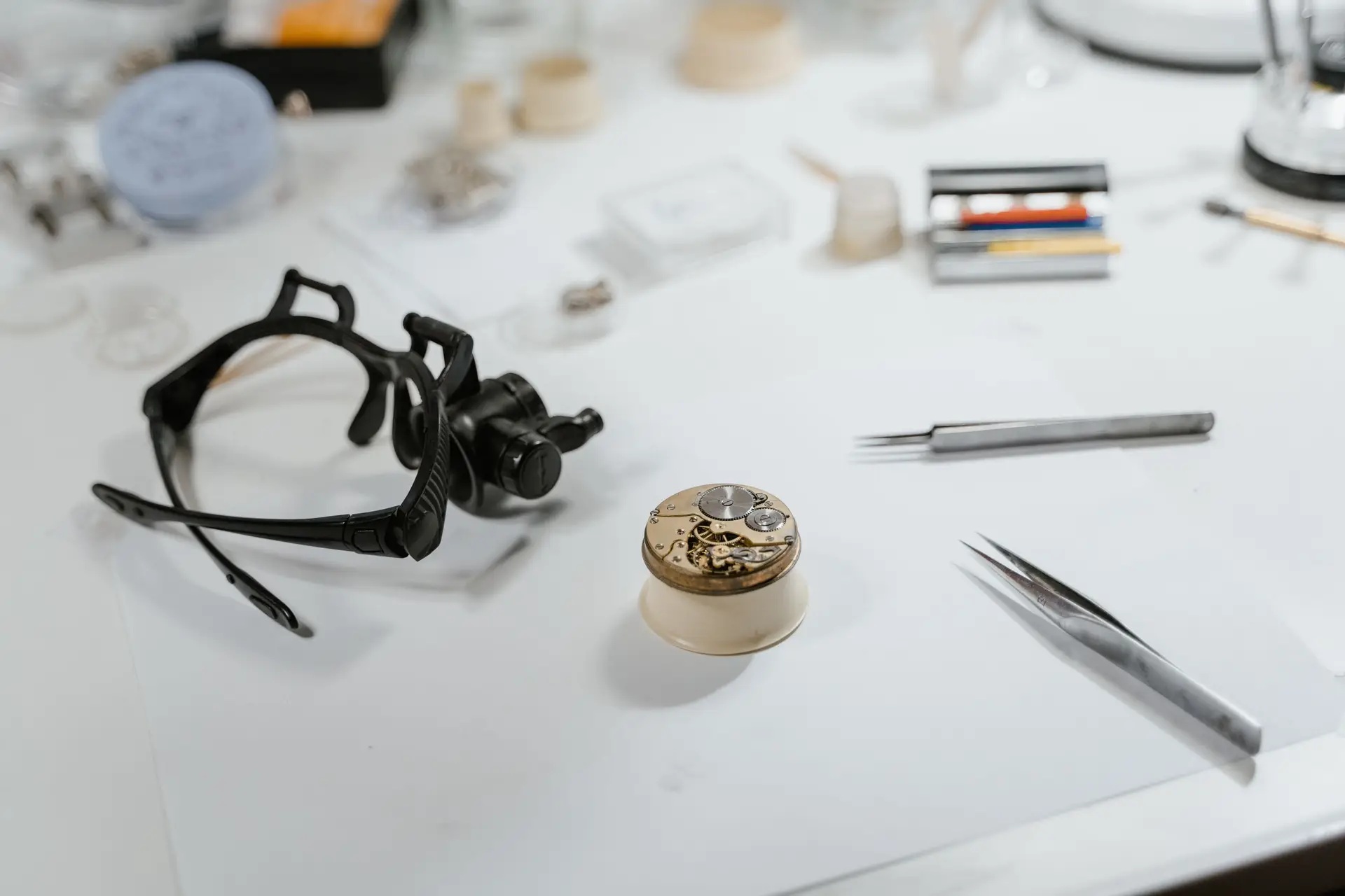 Watchmaker handling a brass clock movement in a workshop