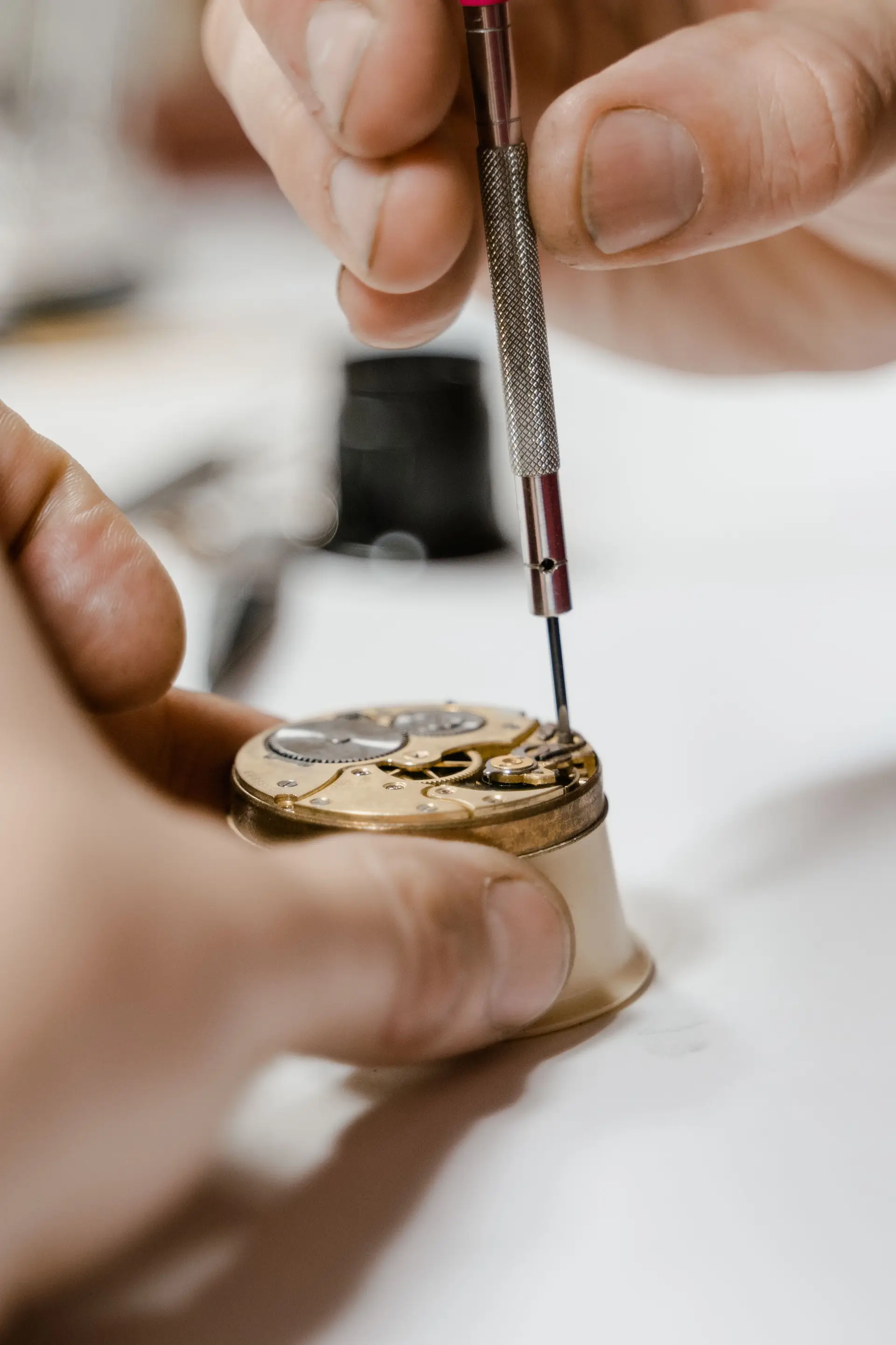 Fine tweezers used on a compact watch movement
